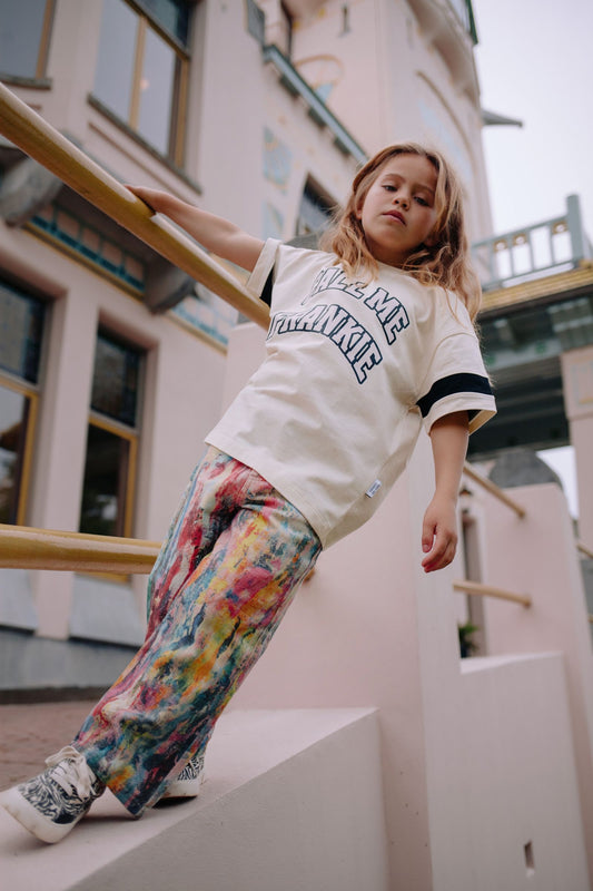 Meisje draagt kleurrijke jeans met verfspetters