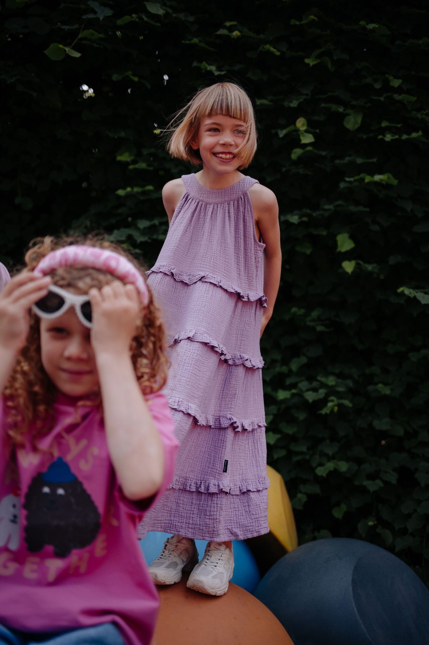 meisje draagt de lila maxi jurk van daily brat