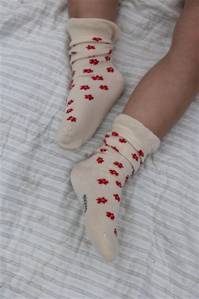meisje draagt ecru sokken met rode bloemetjes van minipop
