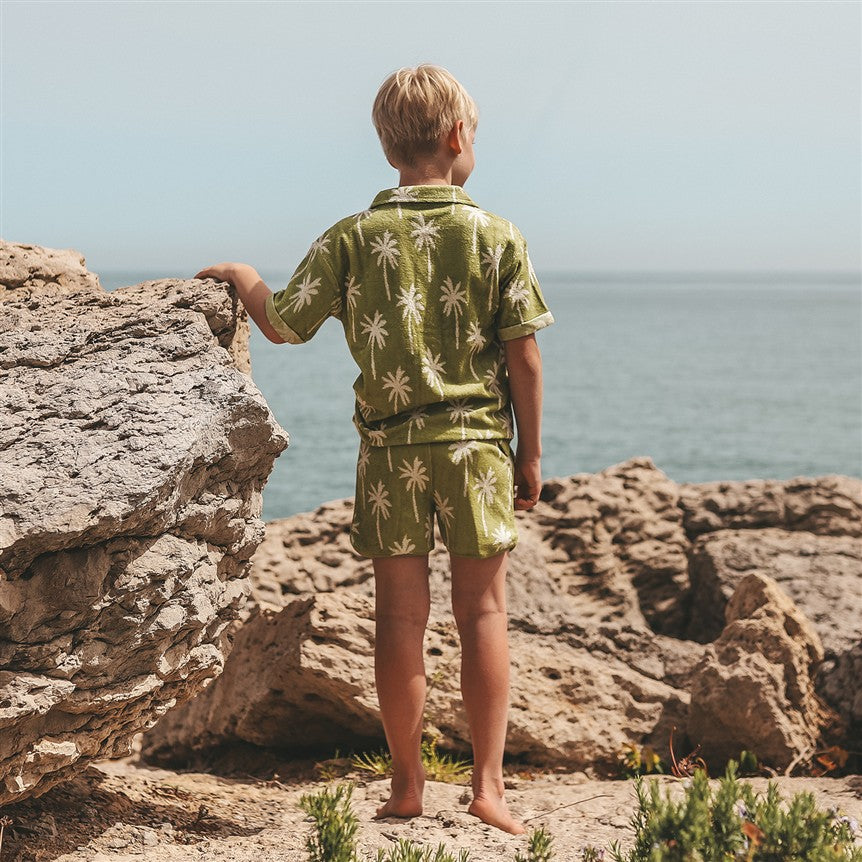 Kind in luchtig hemd met palmbomen achterkant