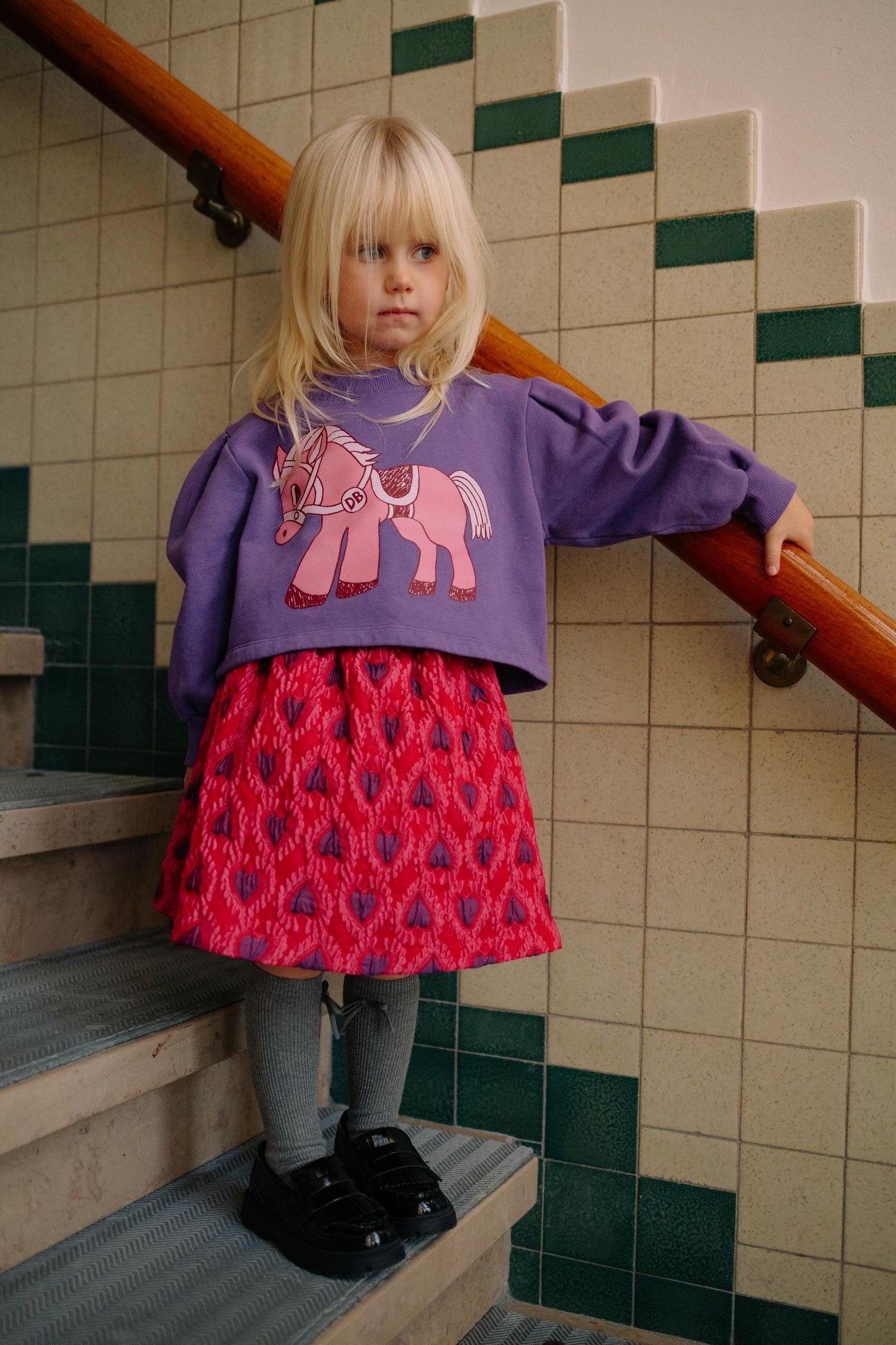 Paarse kindertrui met roze pony op de voorkant.