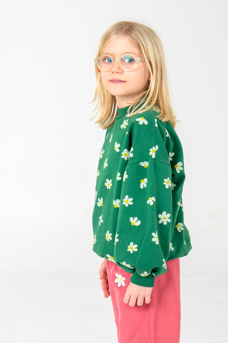 Groene kindertrui met vrolijke bloemenprint.