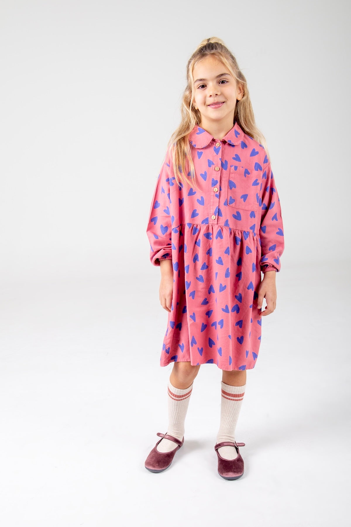 Kinderjurk van woven stof met roze hartjesprint.