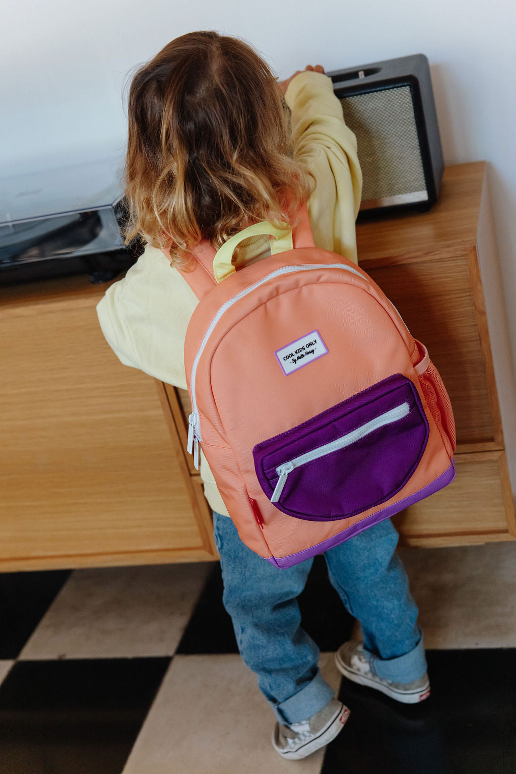 meisje draagt rugzak mini peach pop van hello hossy
