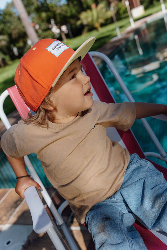 Kind draagt oranje pet Mini Sunrise
