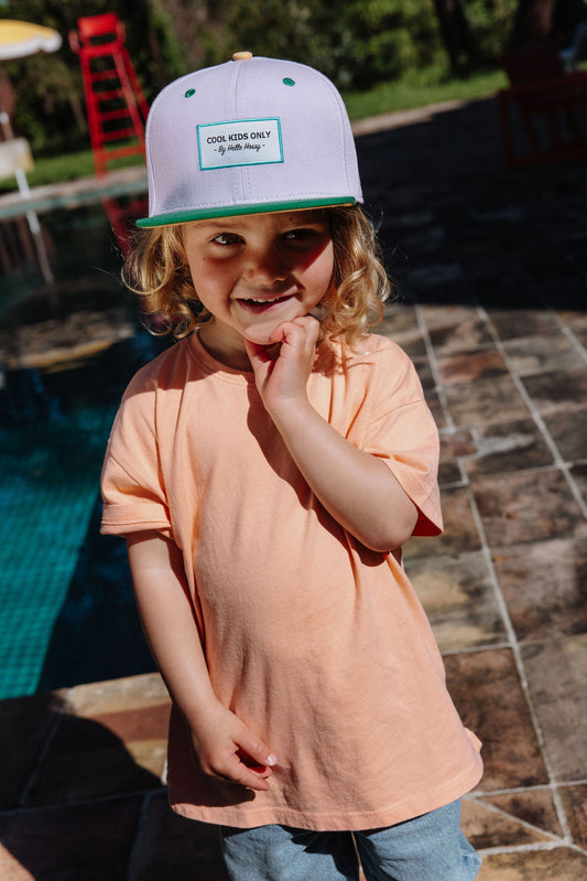 Kind draagt groene pet Mini Greenberry
