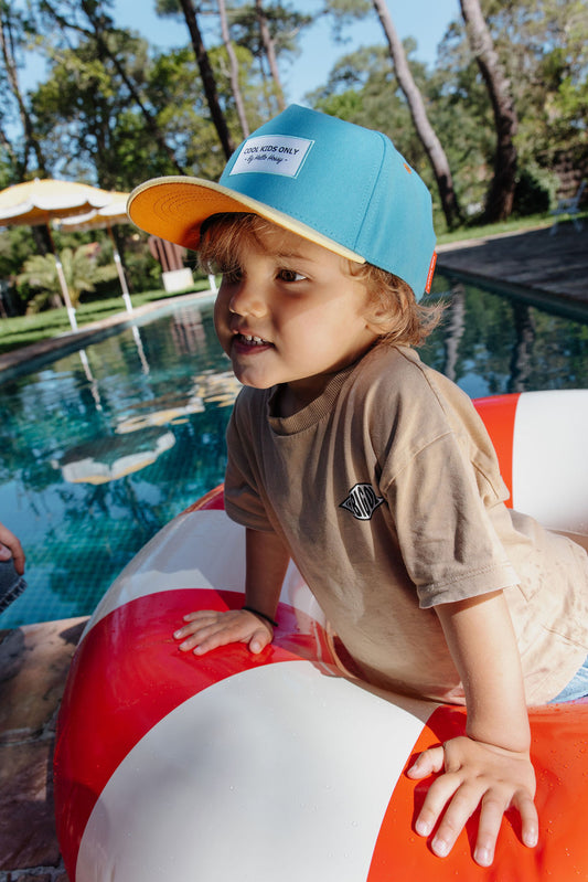 Kind draagt blauwe pet Mini Sunny Blue