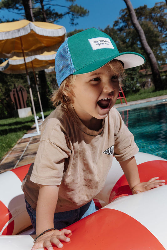 Kind draagt groene pet Mini Lawn
