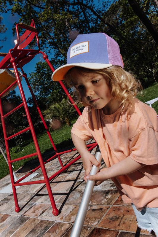 Kind draagt paarse pet Mini Iris
