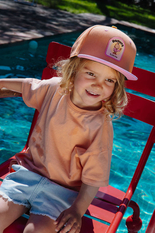 Kind draagt pet Donuts
