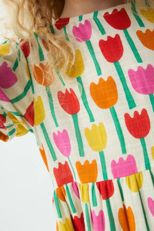 Detail kinderjurk met all-over print van kleurrijke tulpen