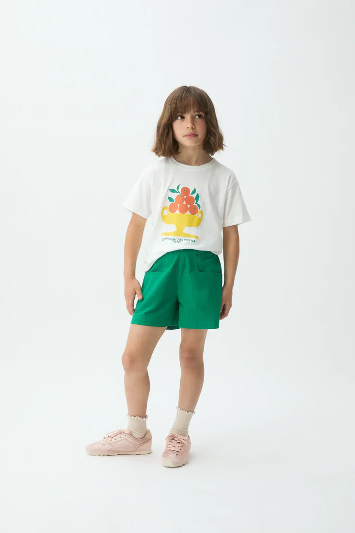 Meisje draagt groene short en t-shirt met citrusprint van Compañia Fantástica