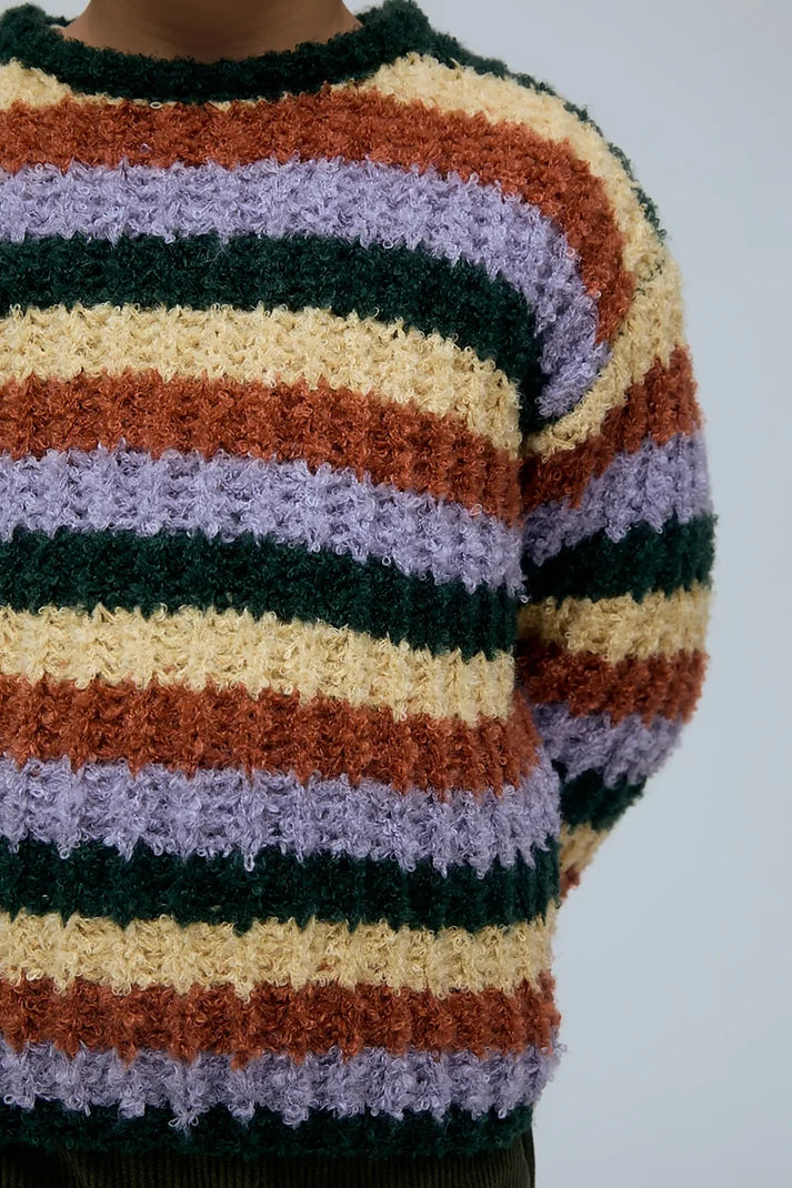 Kindertrui met diagonale strepen in warme en zachte kleuren.