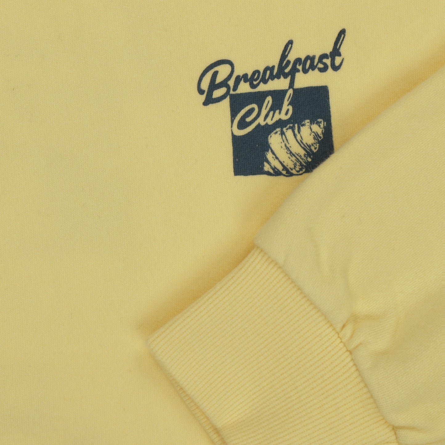 detail opdruk breakfast club op gele sweater