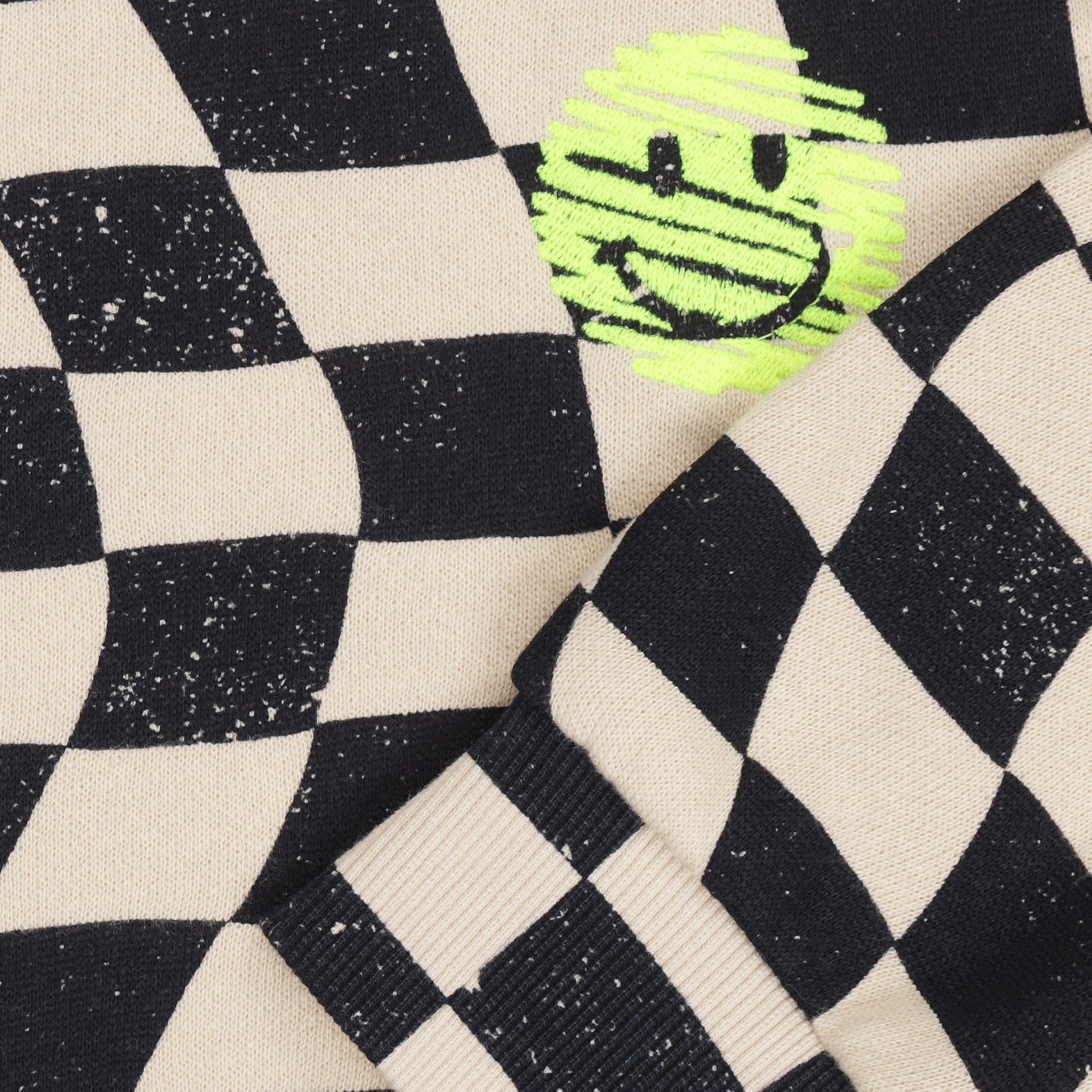 detail geborduurde smiley op dambord patroon