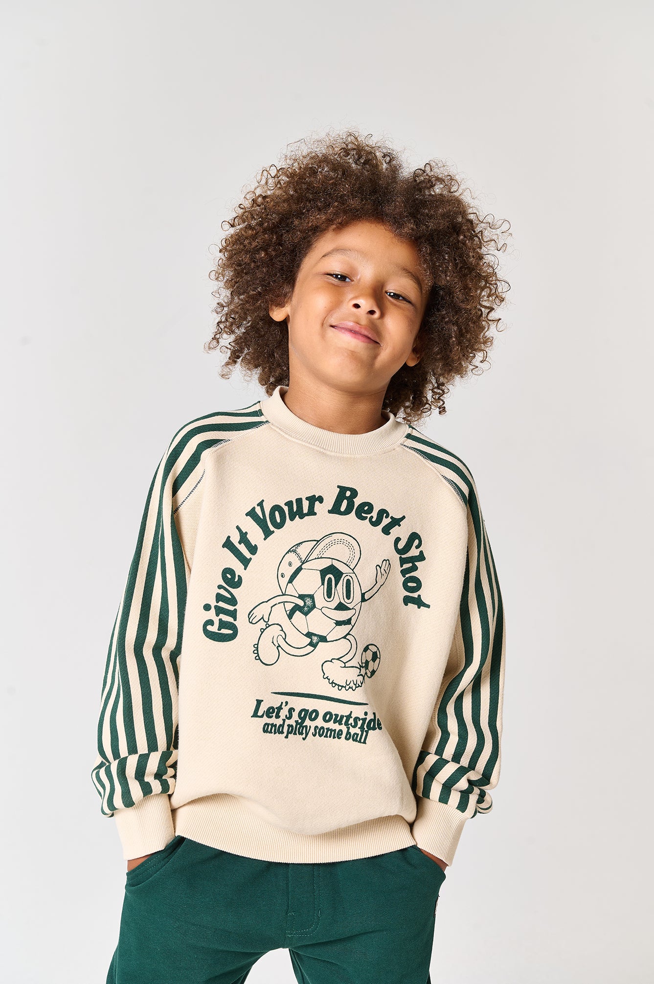 Trendy jongenssweater met voetbalprint en gestreepte mouwen.