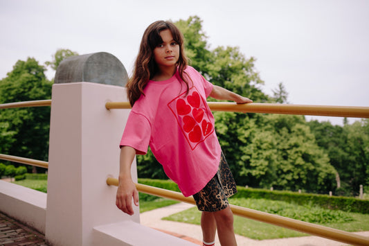 Meisje draagt felroze t-shirt met hartjes