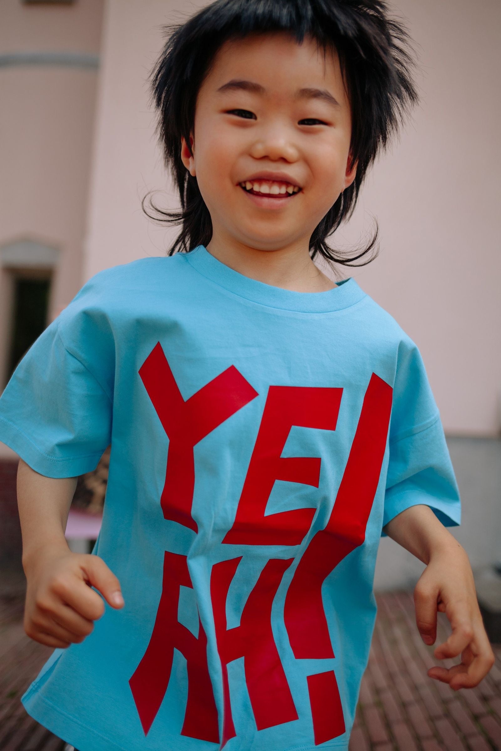 Detail YEAH opdruk op turquoise t-shirt
