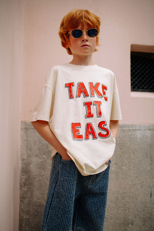 Jongen draagt ecru t-shirt met Take It Easy print
