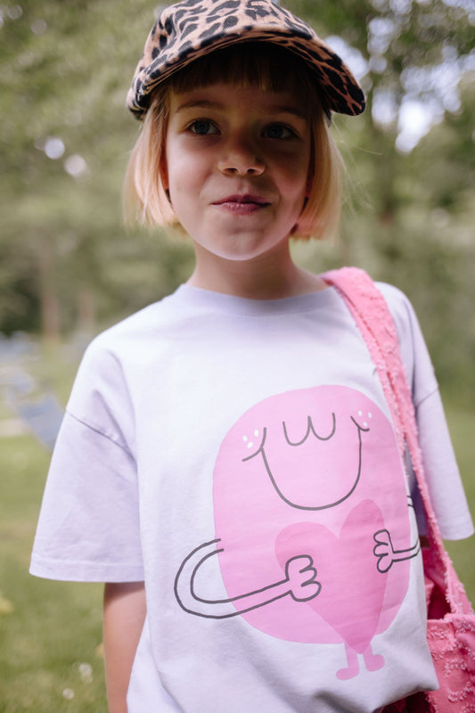 Detail roze hartjesprint op lila t-shirt