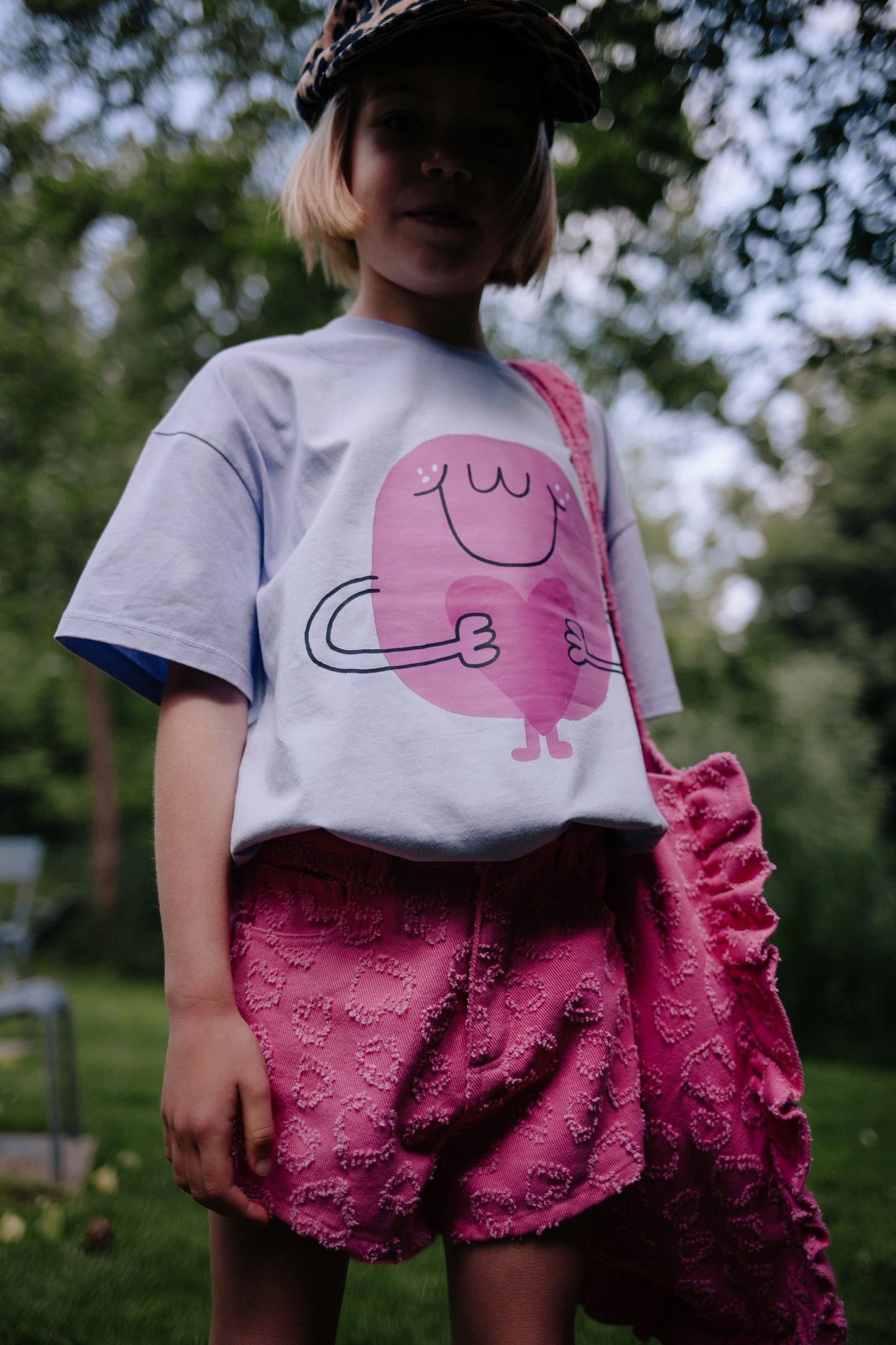 Meisje draagt lila t-shirt met hartjes
