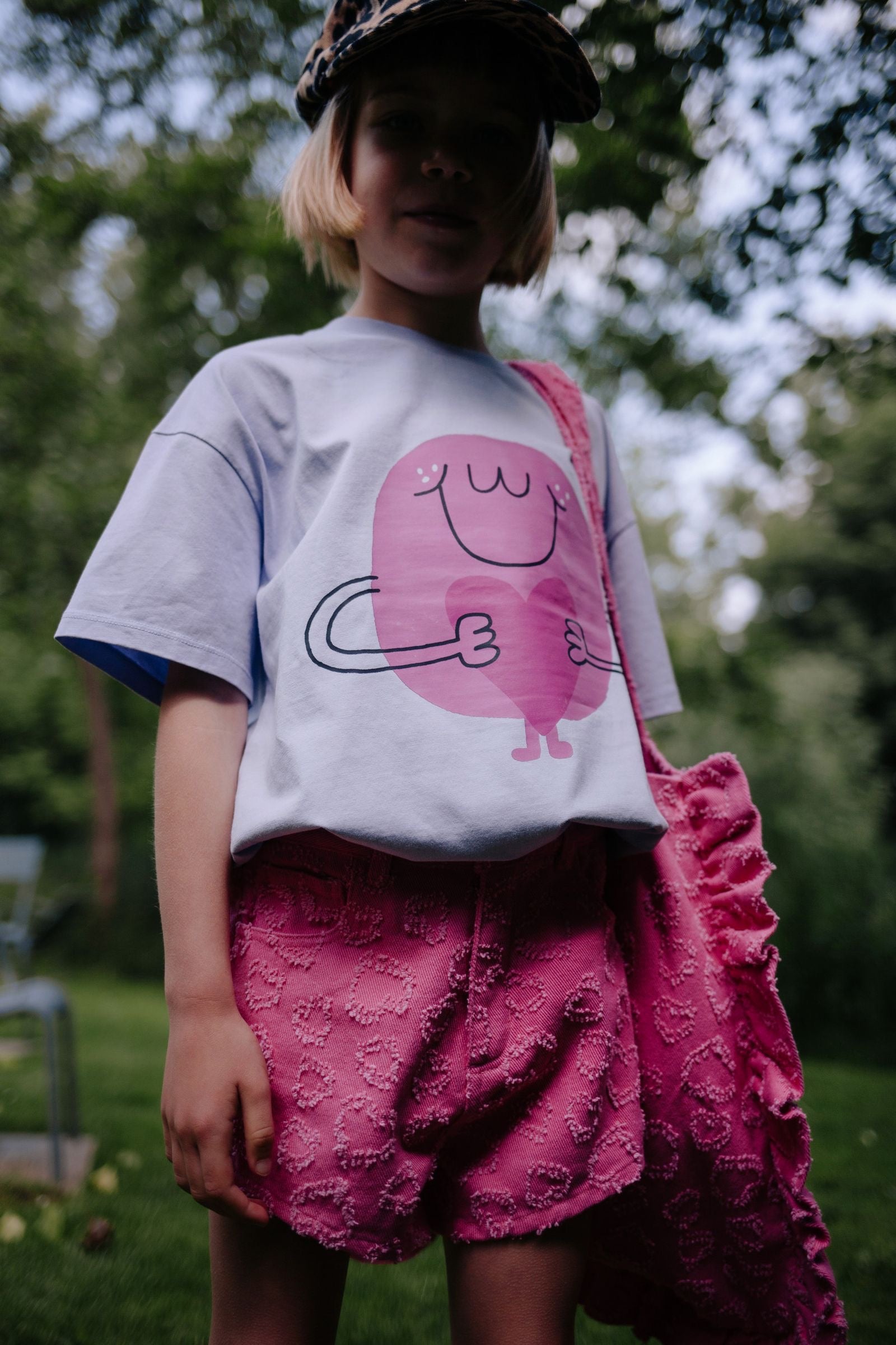 Meisje draagt lila t-shirt met hartjes
