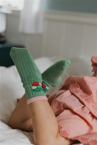 kind draagt lichtgroene sokken uit bamboo met aardbei