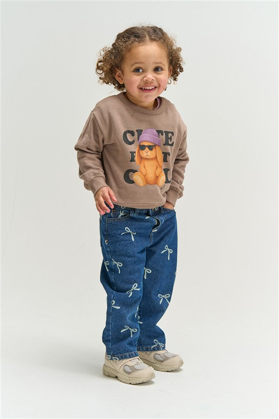 Meisjes jeans met all-over strikjes patroon in blauwe denim.