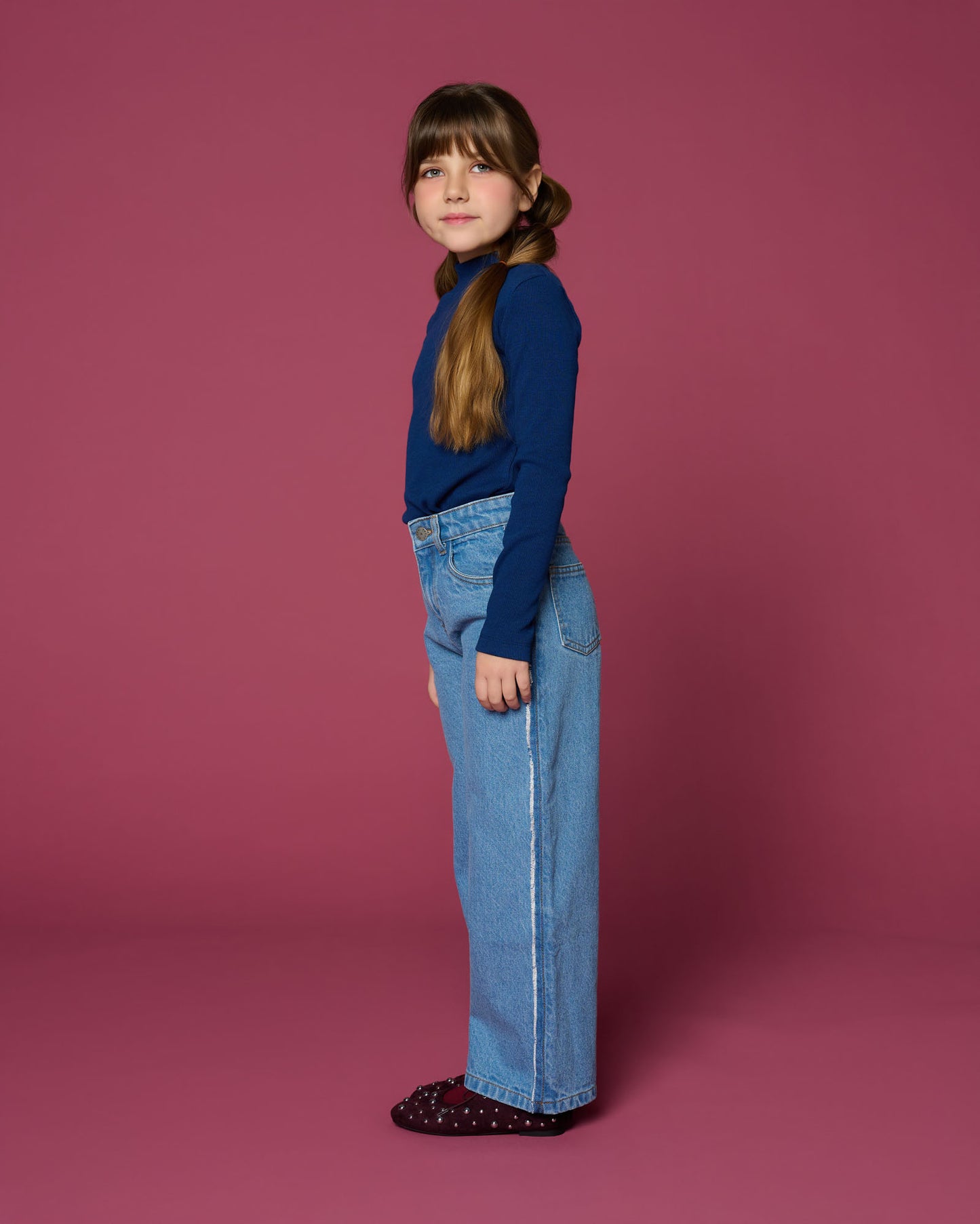 meisje draagt wide leg jeans met opvallende zijnaden zijaanzicht