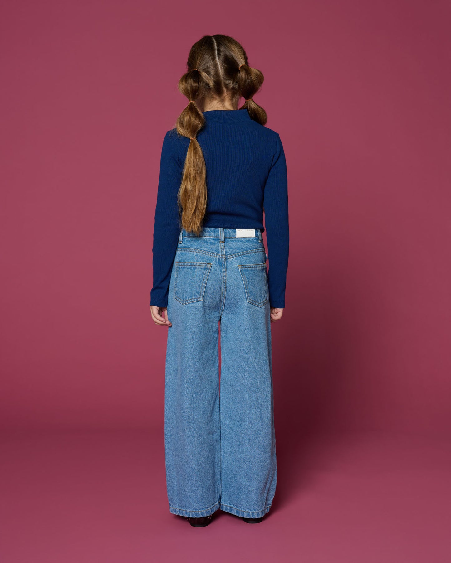 meisje draagt wide leg jeans van petit blush achteraanzicht