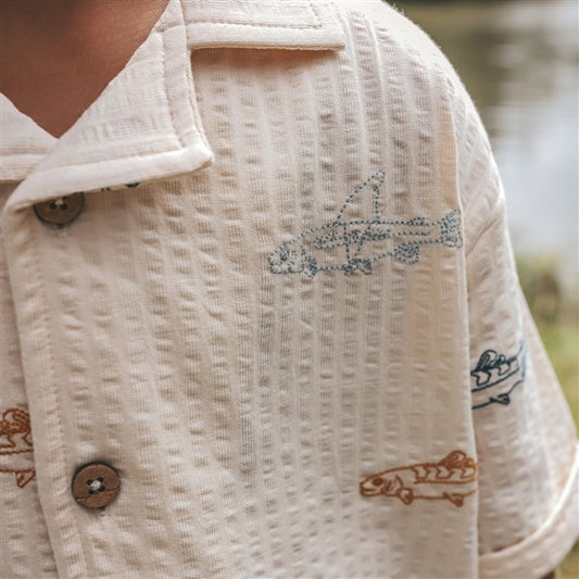 detail geborduurde vissen op ecru kinderhemd
