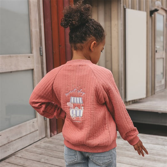 meisje draagt quilted jacket sweet shop van your wishes achterzijde