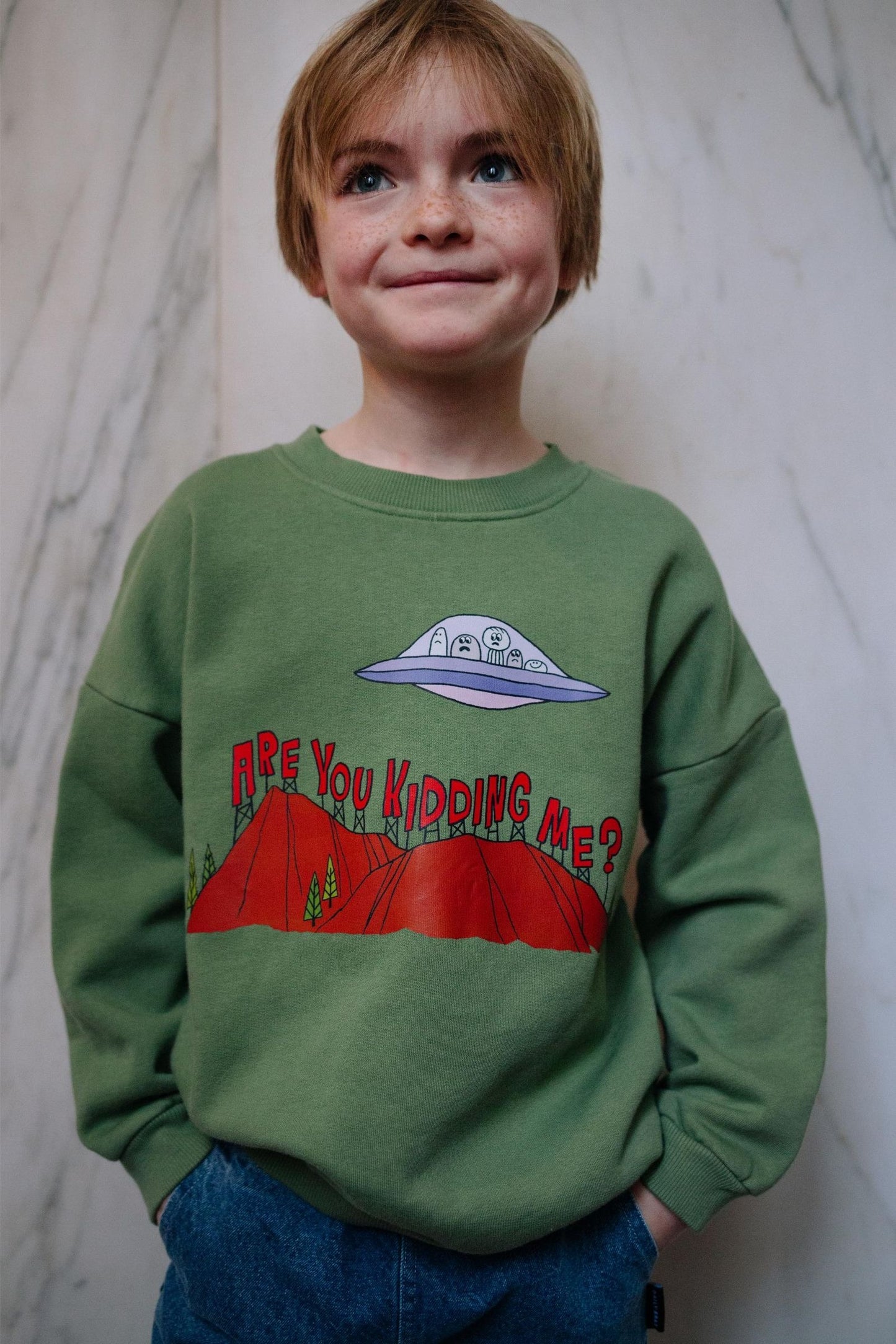 Groene jongenssweater van Daily Brat met berglandschap en UFO.