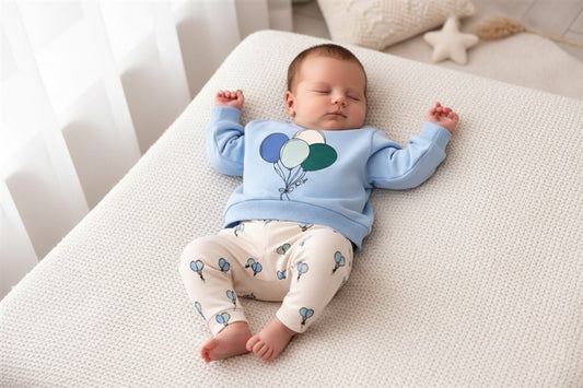 Jongen draagt lichtblauwe sweater met ballonnen