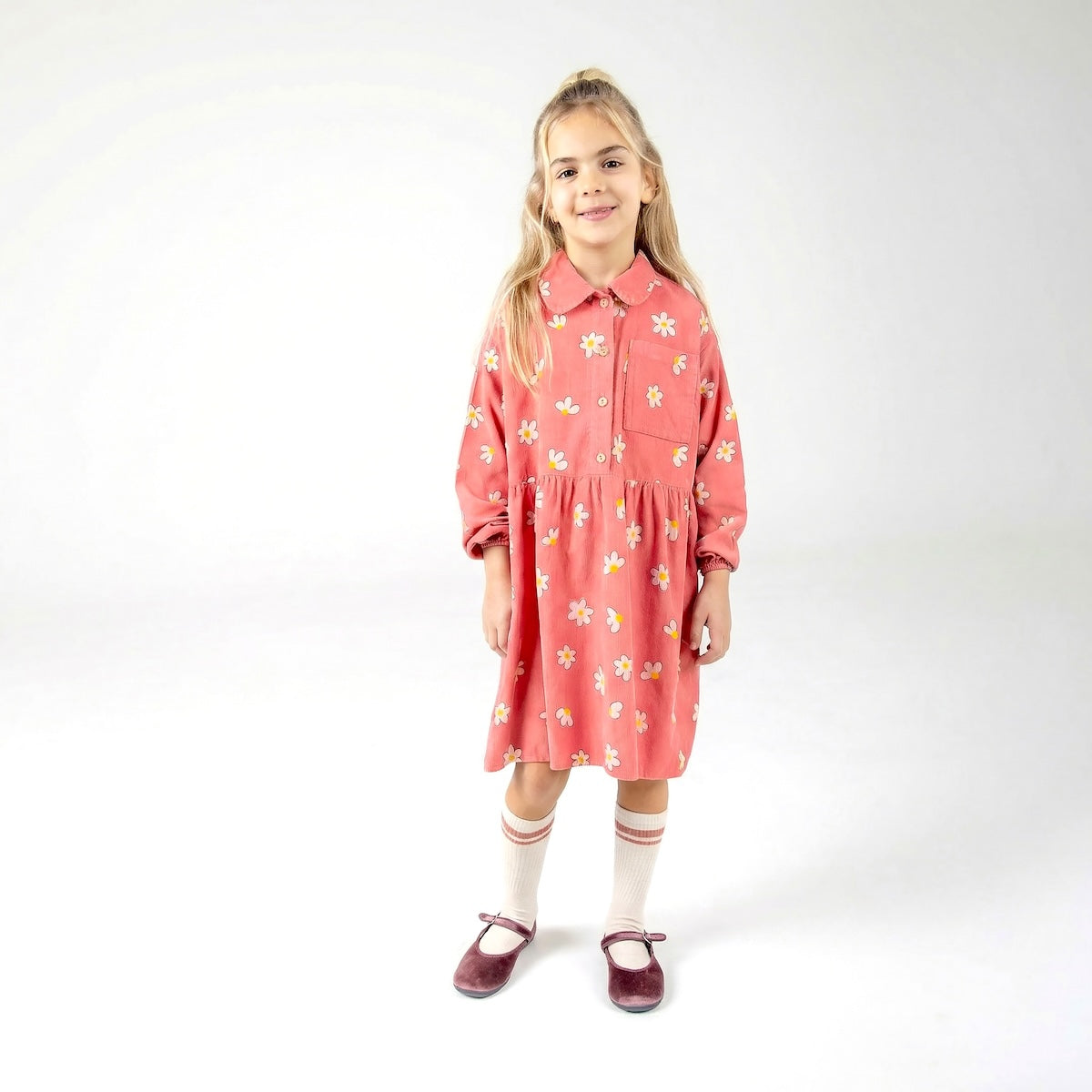 Kinderjurk met knopen en vrolijke daisies all-over print.