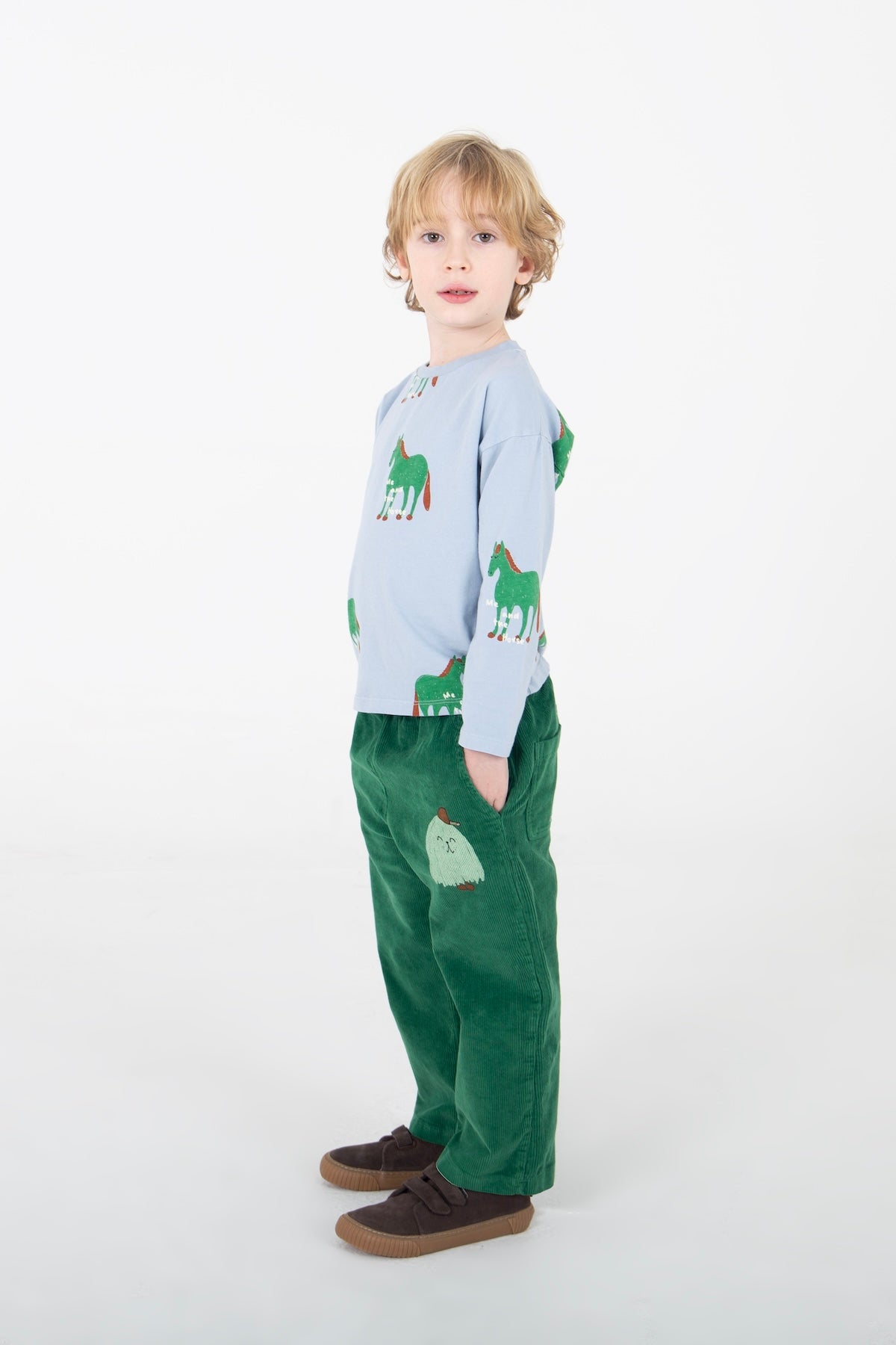 Kinderbroek van ribfluweel met klein monstertje op de voorkant.