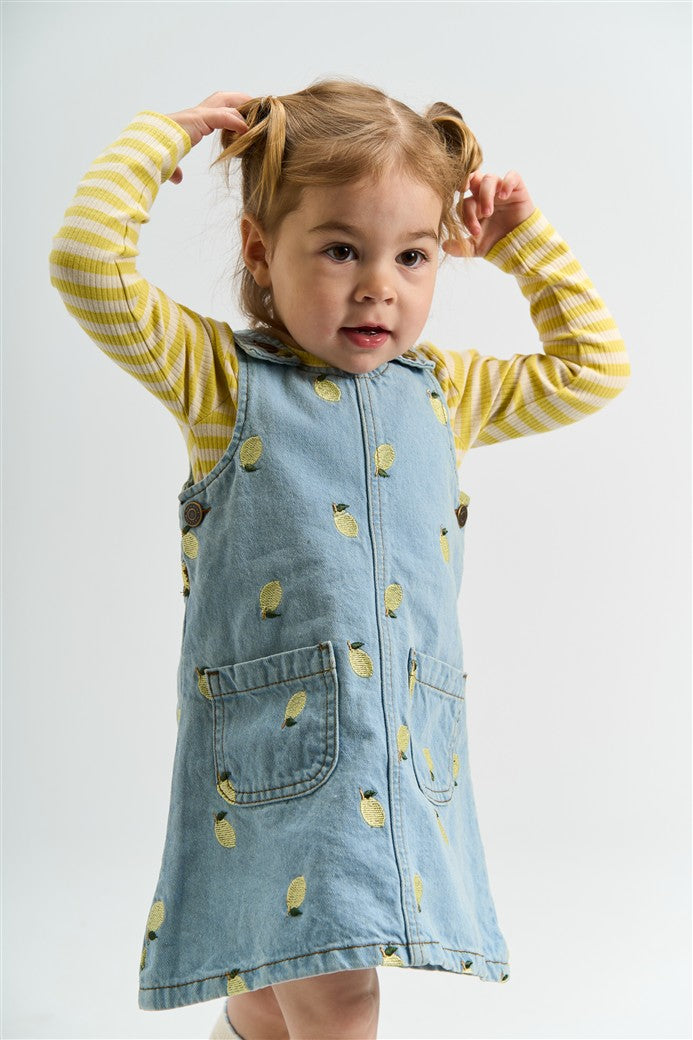 meisje draagt denim dress saja met geborduurde citroenen en fro longsleeve van the new