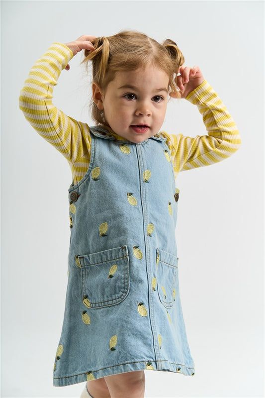meisje draagt denim dress saja met geborduurde citroenen en fro longsleeve van the new