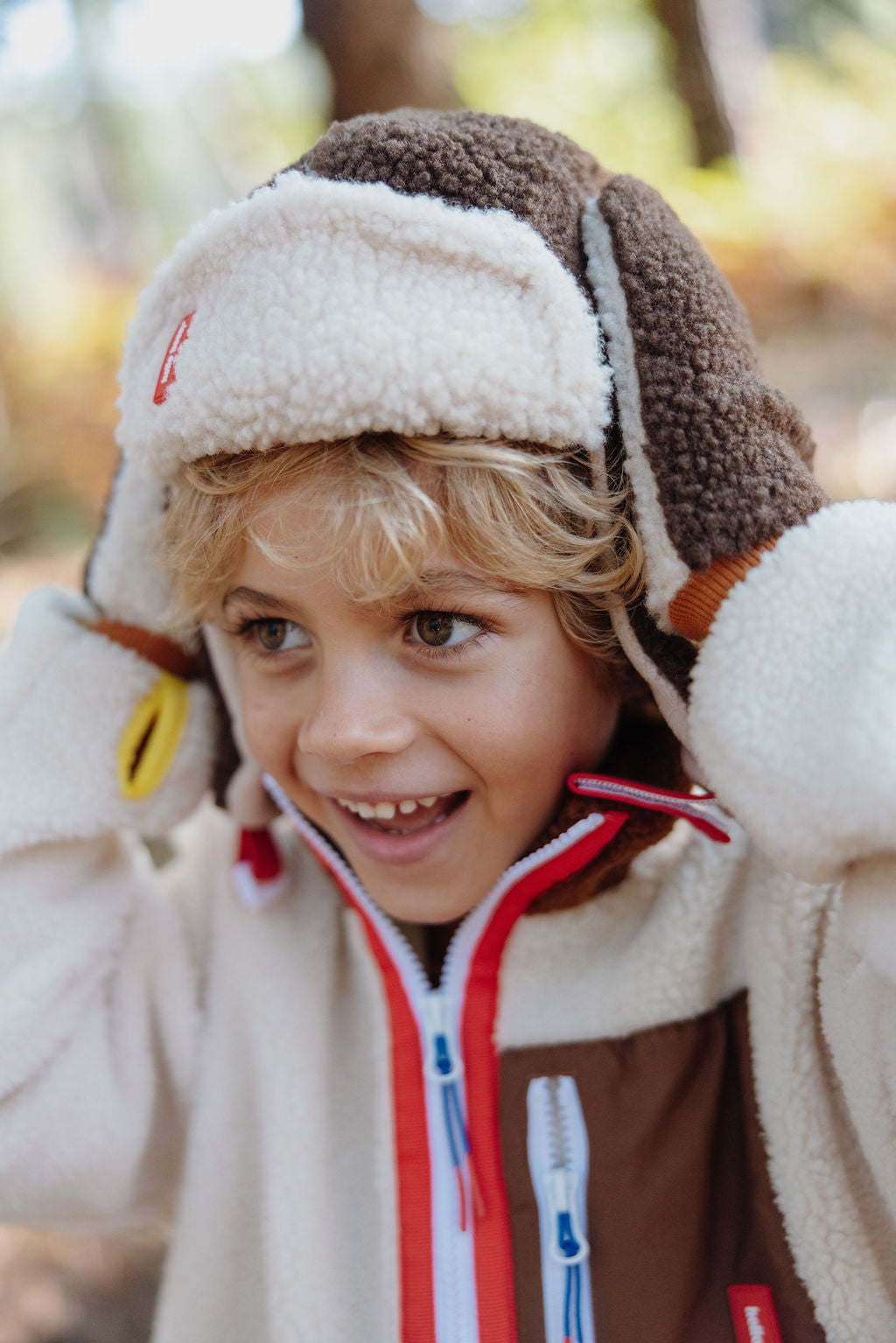 Kinder wintermuts in bruin en wit met zachte teddy structuur.