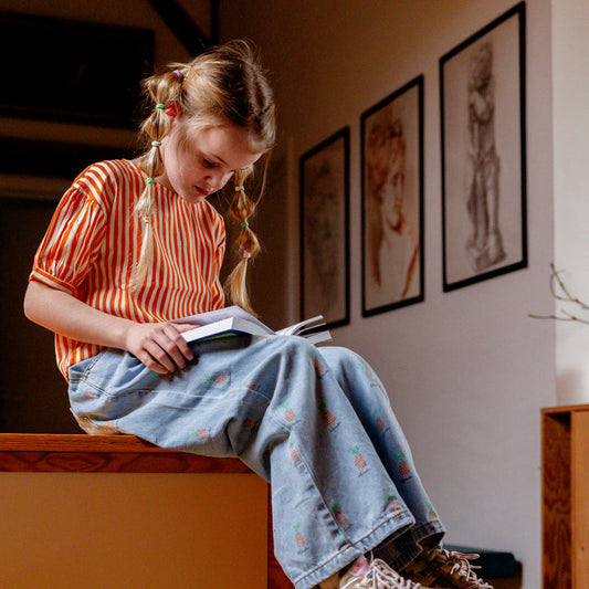  Meisje draagt oranje kindertopje met strepen van Compañia Fantástica
