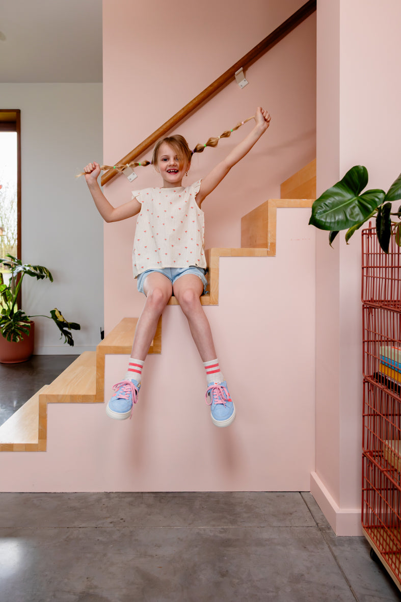 Meisje draagt ecru top met bloemen