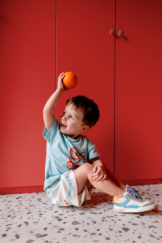 Jongen draagt lichtblauw t-shirt met kreeft en badstof broekje met krabbenpoten