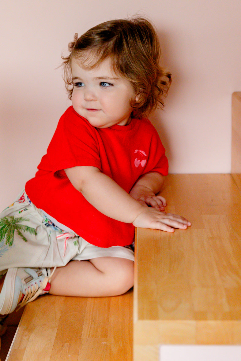 Kind draagt ecru short met zomerse print en Grenadine badstof top met kersen van Petit Blush