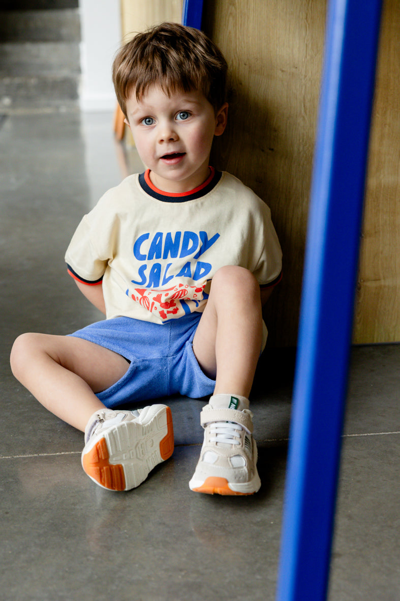 Jongen draagt blauwe badstof short met candy salad tshirt
