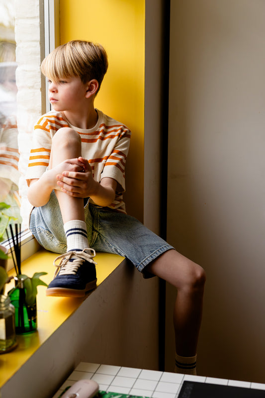 Jongen draagt lichtblauwe jeans bermuda met oker ecru gestreepte tshirt en gestreepte tshirt triad van your wishes