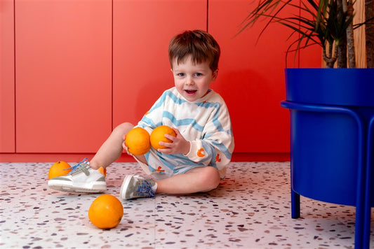 Jongen draagt witte sweater met golven en bijpassend shortje