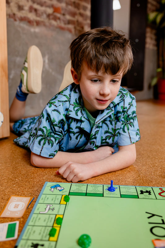 Jongen draagt blauw hemd met palmbomen