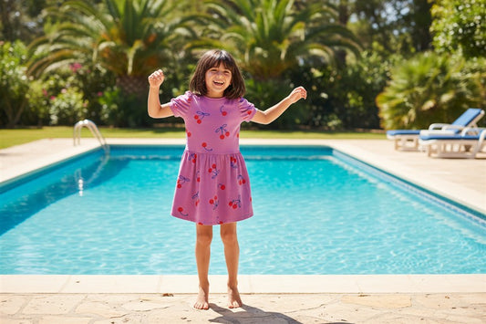 Meisje draagt roze jurk met kersen

