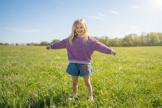 Meisje draagt paars gestreepte badstof sweater en our recipe short van jelly mallow