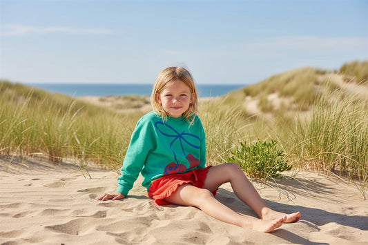 Meisje draagt groene sweater met kers